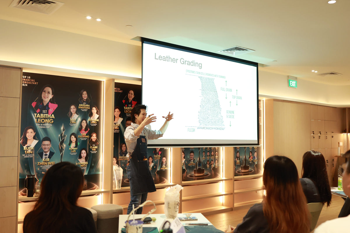 Presenter Keith stands in front of a large screen displaying 'Leather Grading' and a map graphic, speaking to an audience in a seminar or workshop setting.